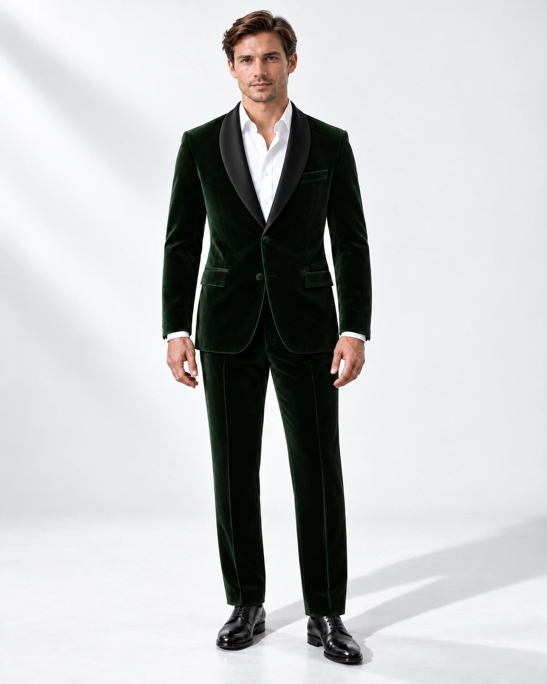 Man wearing a green velvet single-breasted tuxedo with black satin shawl collar, full-length against a white studio background.