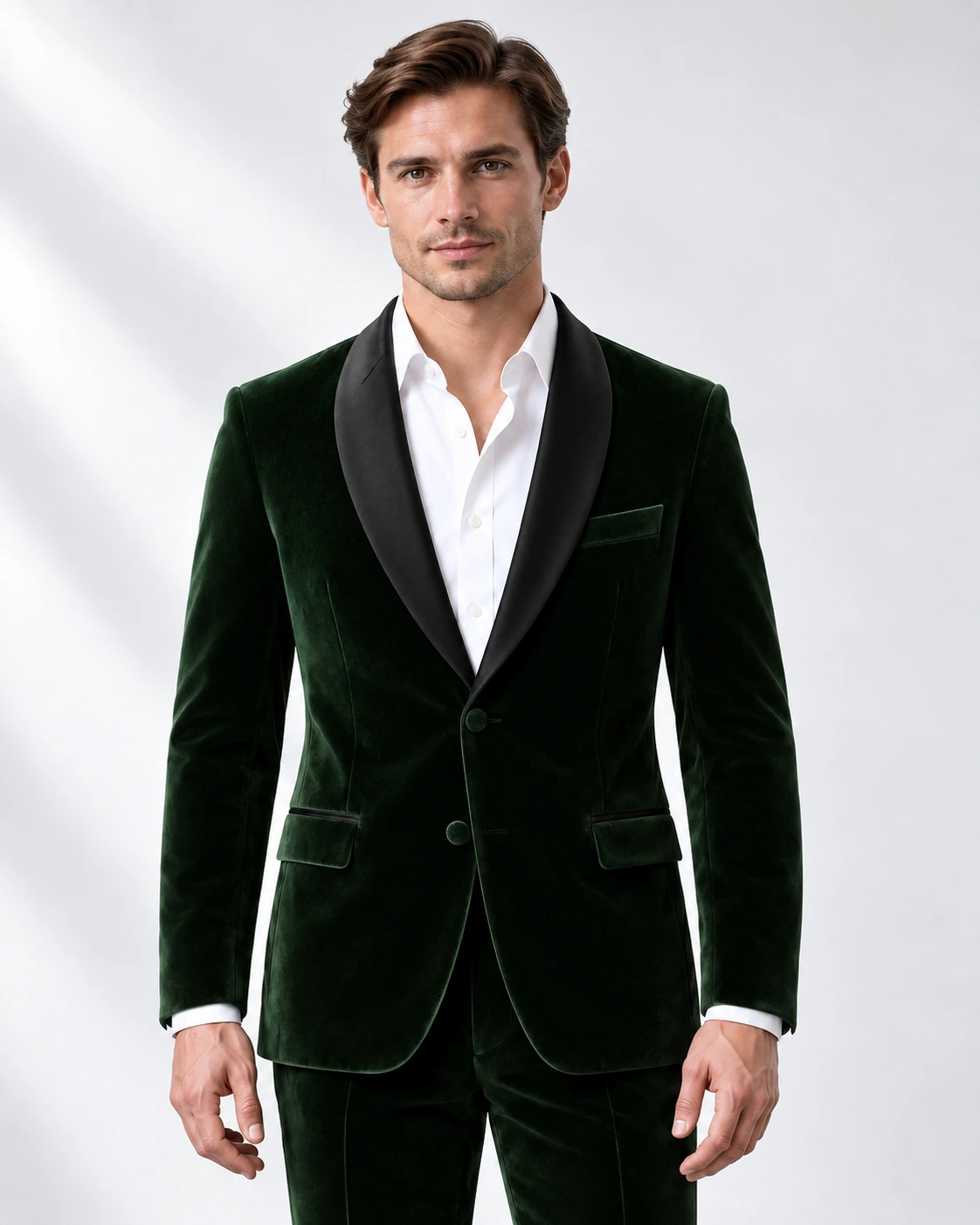 Man wearing a green velvet single-breasted tuxedo with black satin shawl collar, head-to-upper-thigh portrait against a white studio background.