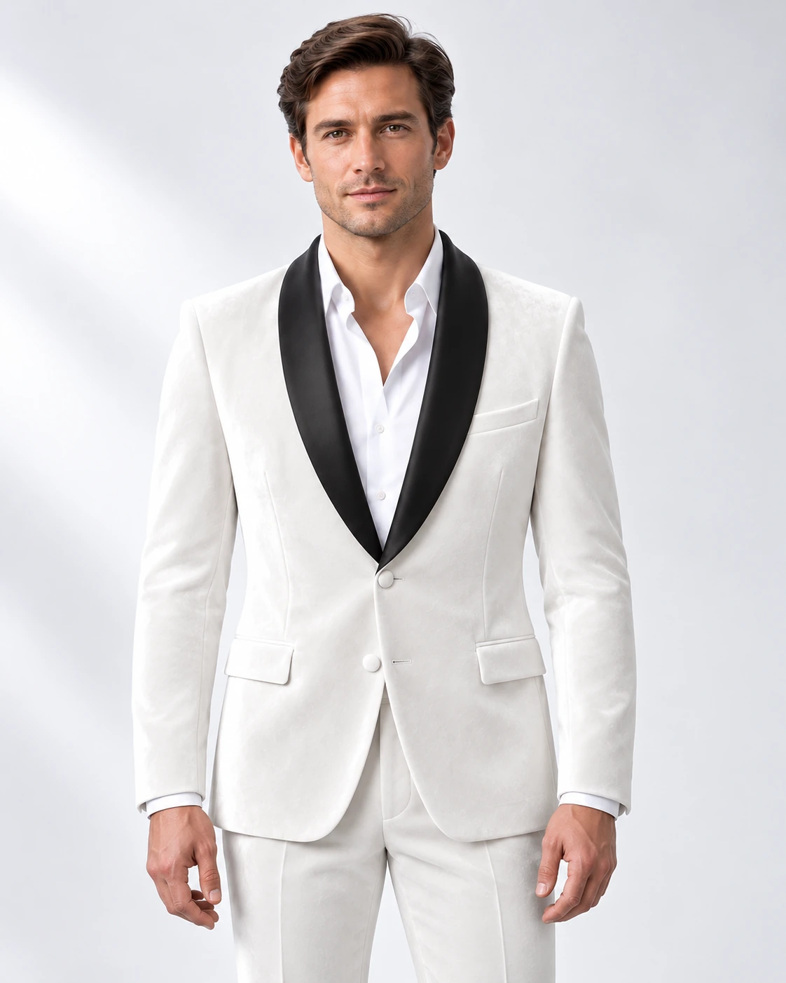 Man wearing a white velvet single-breasted tuxedo with black satin shawl collar, head-to-upper-thigh portrait against a white studio background.