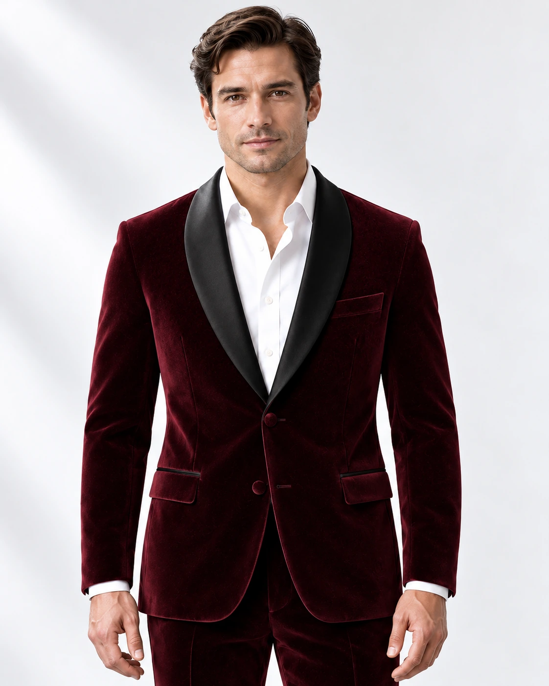 Man wearing a wine velvet single-breasted tuxedo with black satin shawl collar, head-to-upper-thigh portrait against a white studio background.